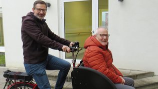 Gotthard Lehner rechts sitzend (Leiter DGD Fachklinik Haus Immanuel) und Werner Wenninger (Therapeutischer Leiter DGD Fachklinik Haus Immanuel) links bei der Übergabe